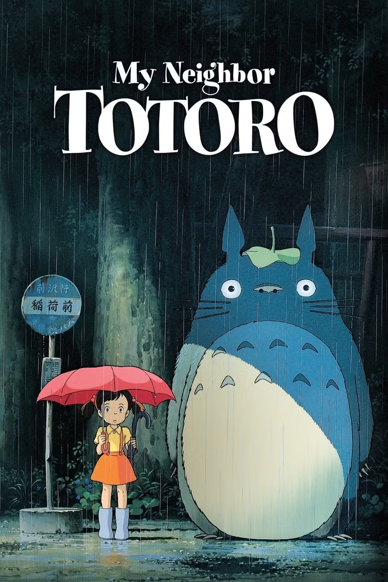A young girl stands under a red umbrella beside a large, friendly creature with a leaf on its head, in the rain near a bus stop, set against a forested backdrop.